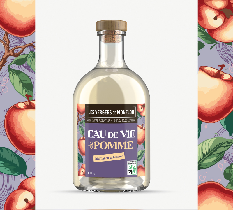 Bouteille d'Eau de Vie de Pomme Les Vergers de Monflou avec étiquette illustrée sur fond violet, création de packaging alimentaire et étiquette produit par Well Com Studio Graphique à Albi.