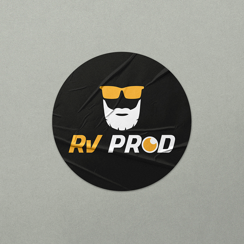 Sticker rond noir affichant le logo RV PROD (visage stylisé avec barbe et lunettes), création d'identité visuelle et goodies par Well Com Studio graphique à Albi.